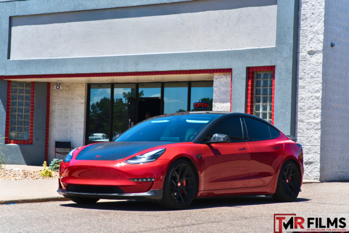 Red Tesla with sleek window tint for enhanced privacy and UV protection.